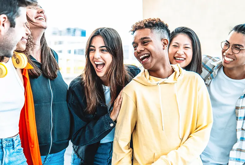 Group of friends laughing together outside.