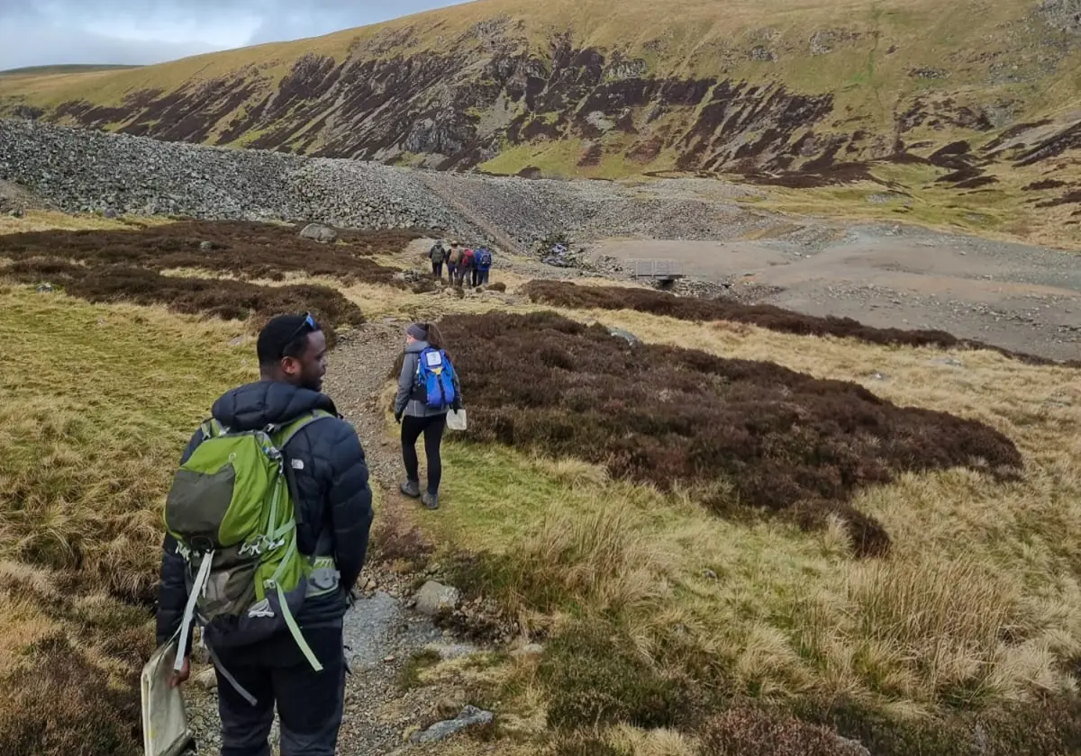 Hikers walking along a mountainous trail.