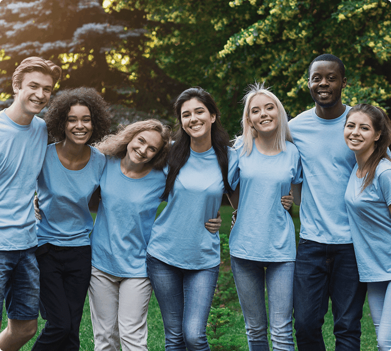 Group of smiling friends in blue shirts.
